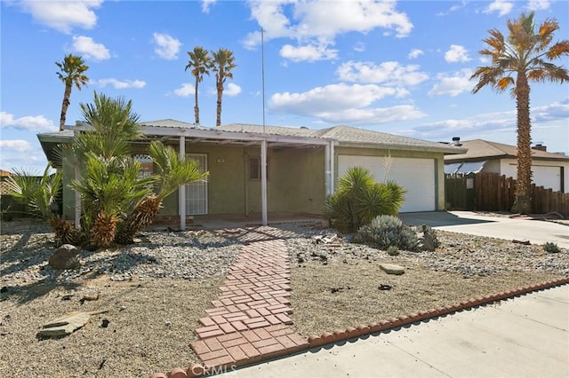 view of front of home with an attached garage, fence, concrete driveway, and stucco siding