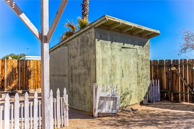 view of shed featuring a gate and fence