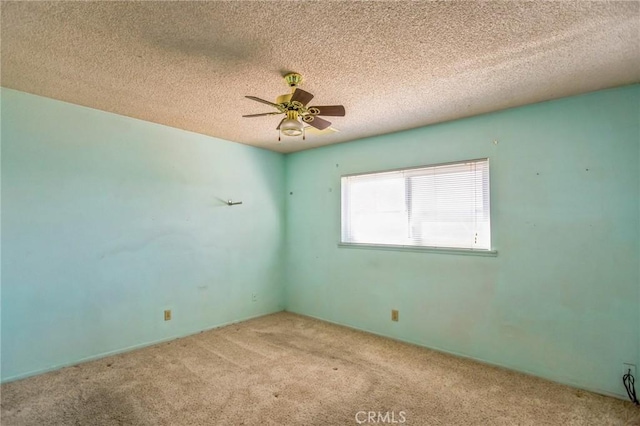 spare room featuring ceiling fan, a textured ceiling, and carpet