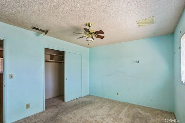 unfurnished bedroom featuring carpet floors, a closet, visible vents, and a textured ceiling