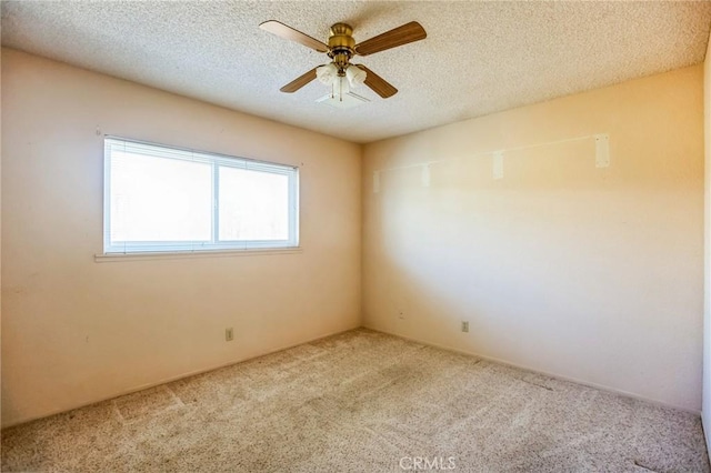 spare room with a textured ceiling, ceiling fan, and carpet