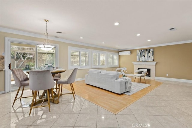 living room featuring light tile patterned floors, ornamental molding, a wealth of natural light, and an AC wall unit