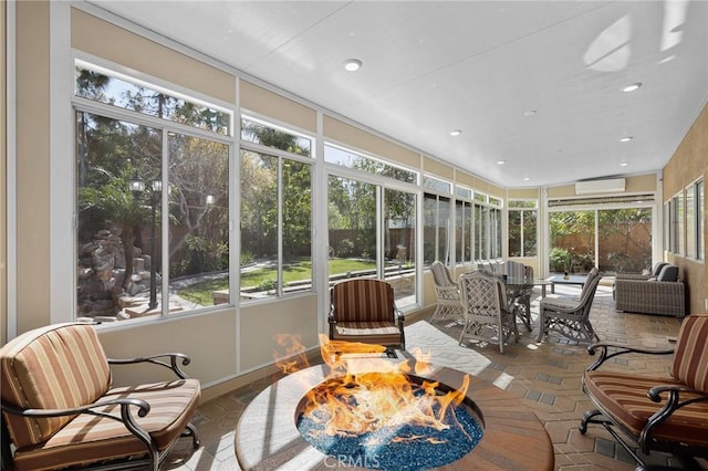 sunroom / solarium featuring a healthy amount of sunlight and a wall unit AC