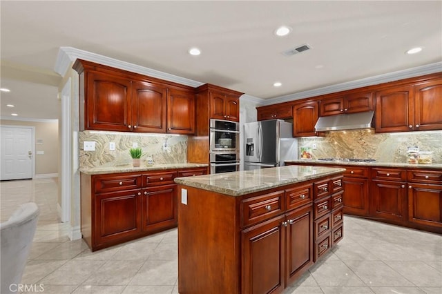 kitchen with under cabinet range hood, visible vents, appliances with stainless steel finishes, ornamental molding, and reddish brown cabinets