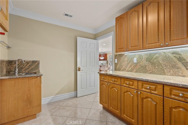 kitchen with ornamental molding, visible vents, a sink, and light tile patterned floors