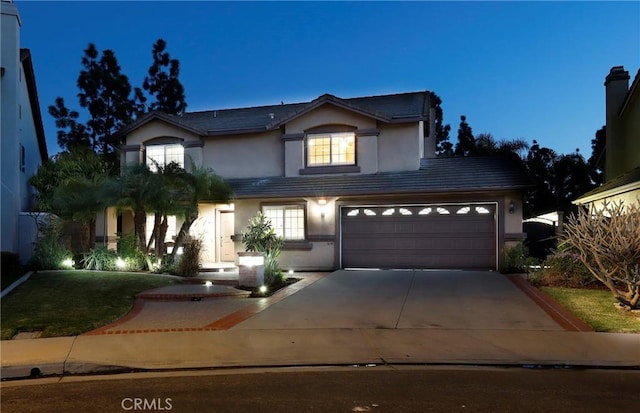 traditional-style home with concrete driveway, a tile roof, and stucco siding