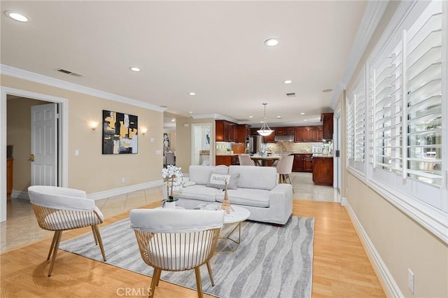 living area with ornamental molding, recessed lighting, visible vents, and baseboards