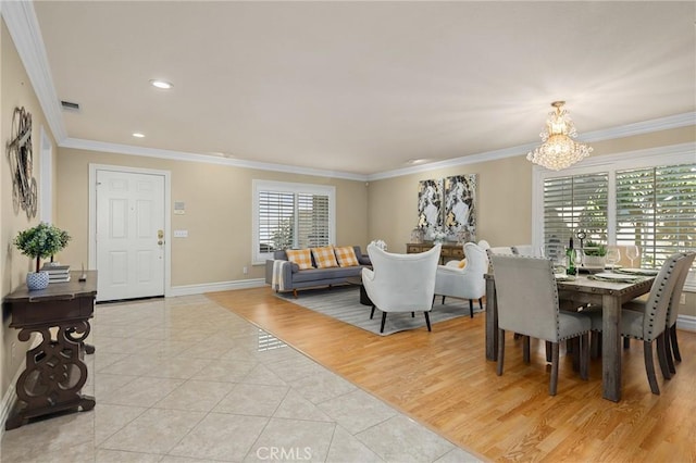 dining area with light tile patterned floors, a notable chandelier, visible vents, baseboards, and ornamental molding