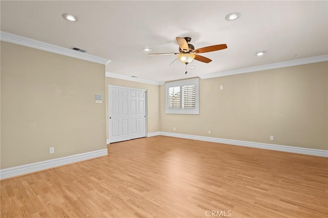 spare room featuring crown molding, light wood finished floors, visible vents, and baseboards