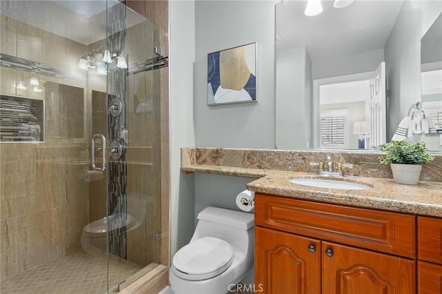 full bath with a stall shower, vanity, and toilet