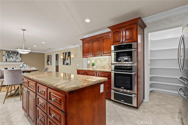 kitchen with a center island, a warming drawer, light tile patterned floors, appliances with stainless steel finishes, and ornamental molding