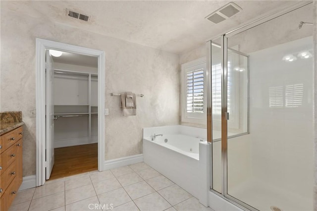 full bathroom with a stall shower, tile patterned flooring, and visible vents