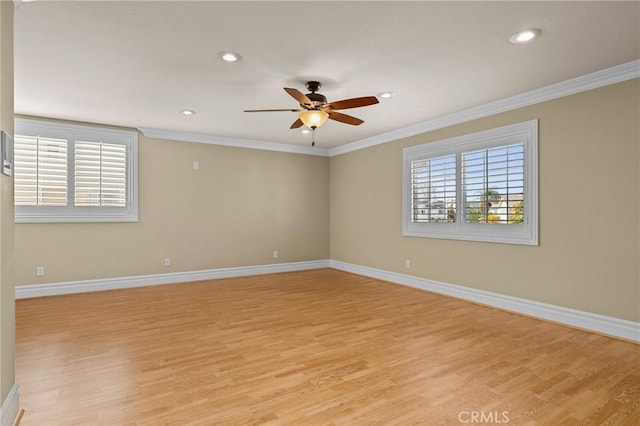 spare room with baseboards, light wood-style flooring, and crown molding