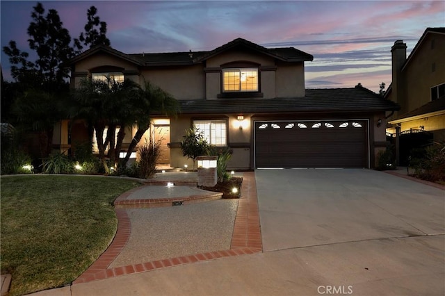 traditional-style home with a front yard, concrete driveway, a tile roof, and stucco siding