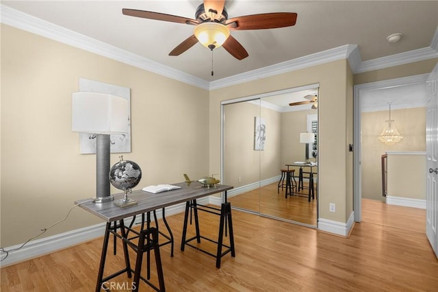 office space with ornamental molding, wood finished floors, a ceiling fan, and baseboards