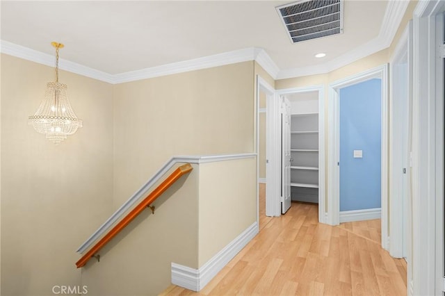 hall featuring crown molding, visible vents, light wood-style floors, an upstairs landing, and baseboards