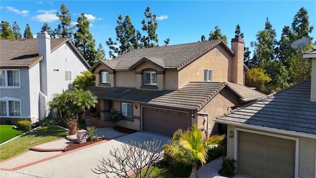 view of front of house featuring a garage, a tile roof, and concrete driveway