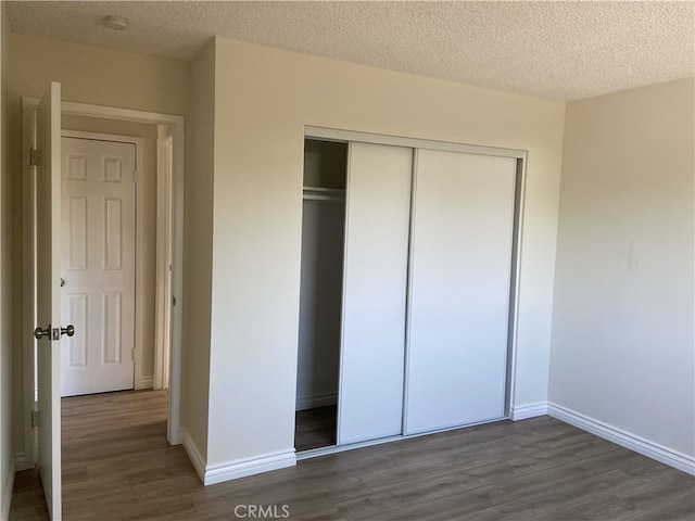 18209 Camino Bello Unit 4, Rowland Heights, CA 91748 - unfurnished bedroom featuring baseboards, wood finished floors, a textured ceiling, and a closet