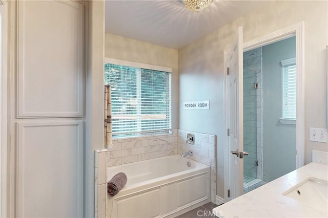 full bathroom featuring a shower, vanity, and a bath