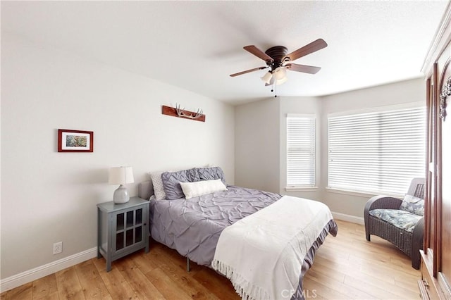 bedroom with light wood-type flooring, ceiling fan, and baseboards