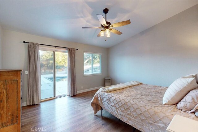 bedroom featuring wood finished floors, a ceiling fan, baseboards, vaulted ceiling, and access to outside