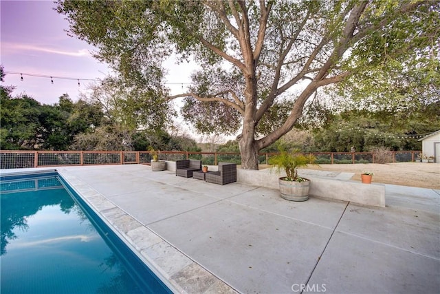 pool at dusk featuring a fenced in pool, a patio area, and fence