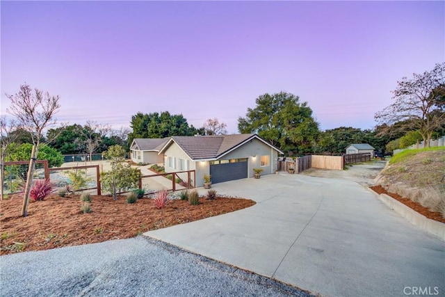 view of front of property with a garage, concrete driveway, fence, and a gate