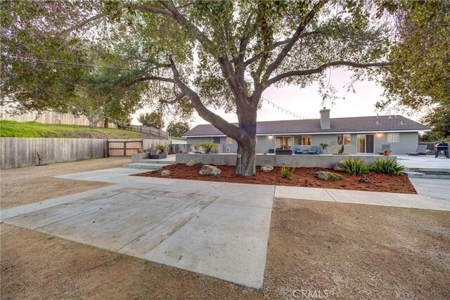 ranch-style house with a chimney and fence