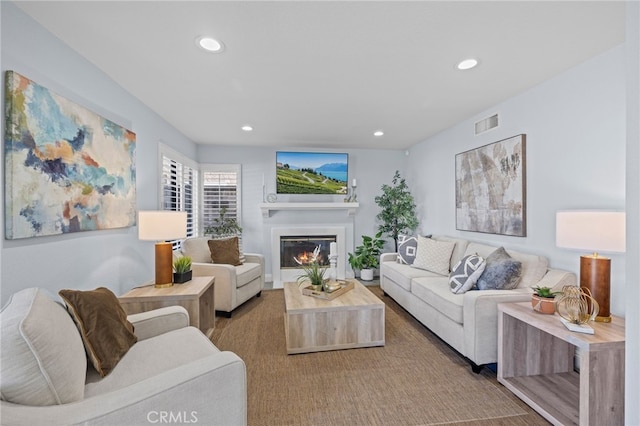 living room featuring recessed lighting, visible vents, and a glass covered fireplace