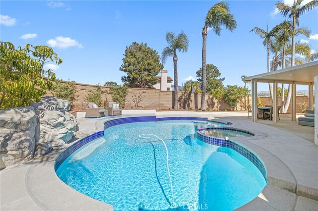 view of swimming pool with a patio area, a fenced backyard, and a pool with connected hot tub