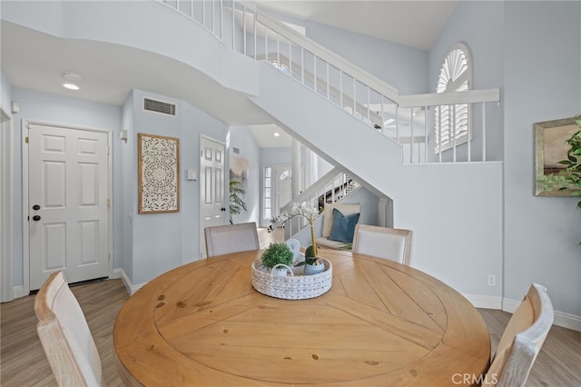 dining area featuring stairs, plenty of natural light, wood finished floors, and visible vents