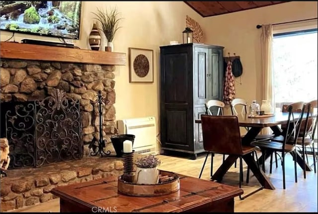 dining area featuring wood finished floors and a stone fireplace