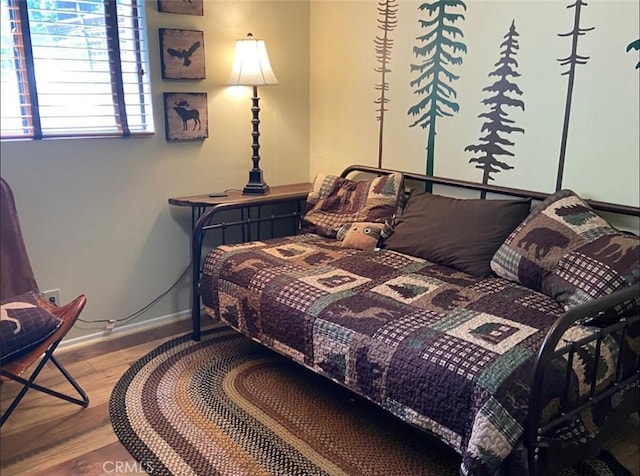 bedroom with wood finished floors and baseboards