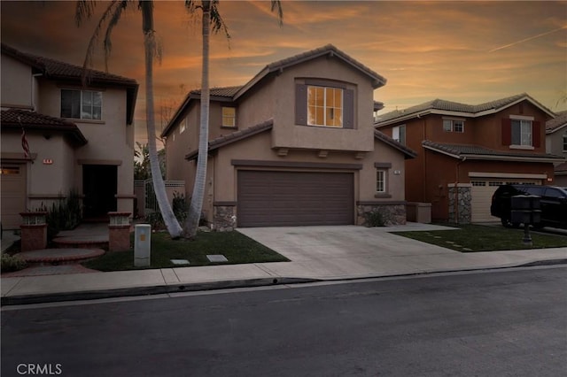 traditional-style house with a garage, stone siding, concrete driveway, and stucco siding