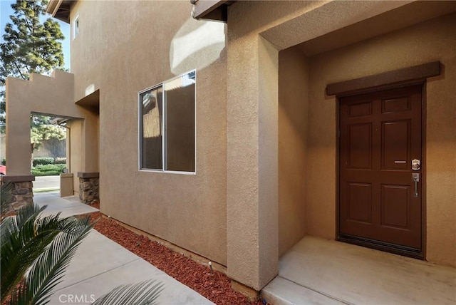 view of exterior entry with stucco siding