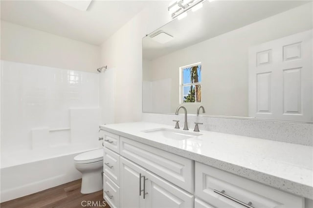 full bathroom with shower / bathtub combination, wood finished floors, vanity, and toilet