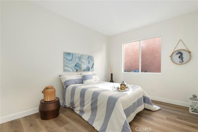 bedroom with wood finished floors and baseboards