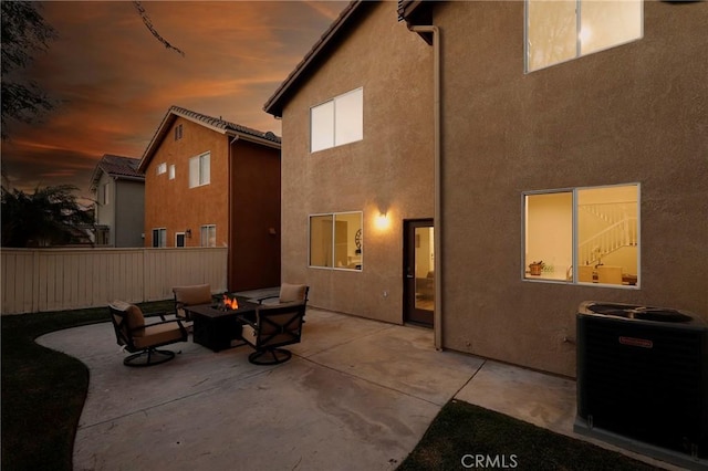 back of house featuring an outdoor fire pit, a patio area, fence, and stucco siding