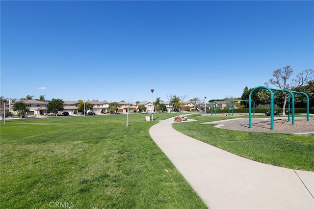 view of property's community with playground community, a yard, and a residential view