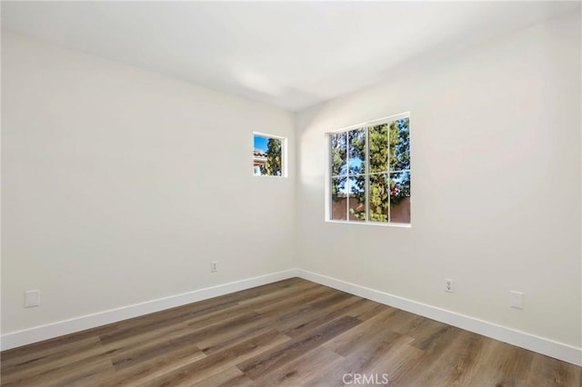 unfurnished room featuring baseboards and wood finished floors