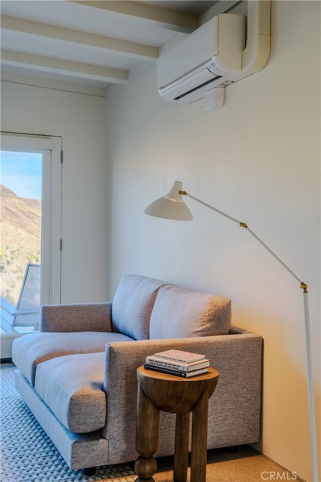 living area featuring beamed ceiling and a wall mounted AC