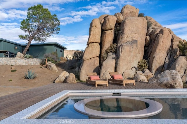 exterior space featuring a wooden deck and an in ground hot tub