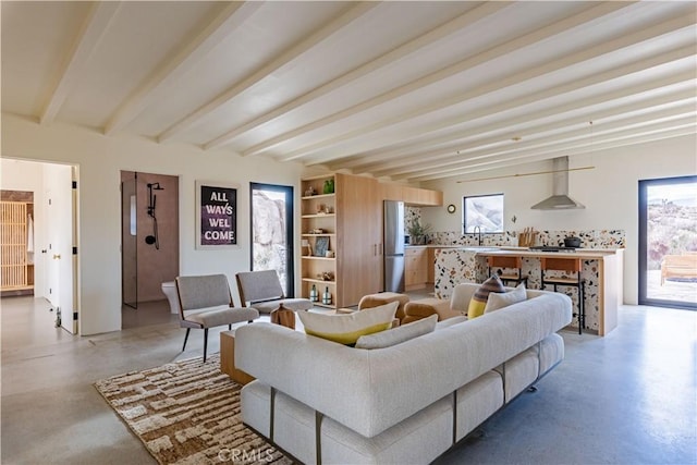 living room featuring finished concrete floors and beam ceiling