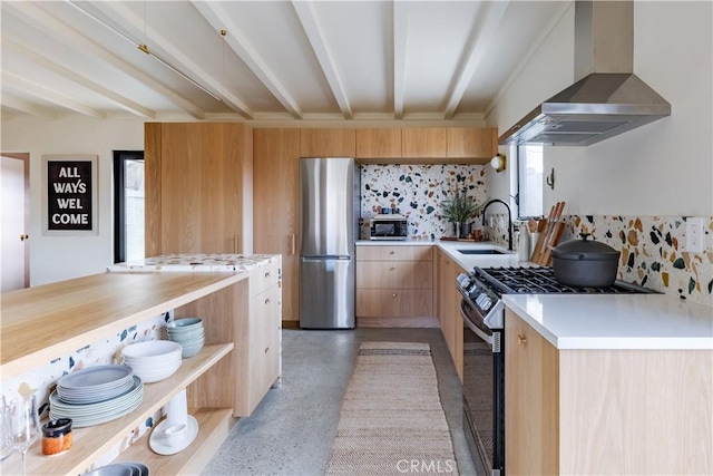 kitchen with stainless steel appliances, light countertops, light brown cabinetry, beamed ceiling, and wall chimney exhaust hood