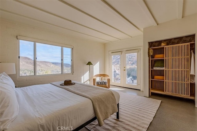 carpeted bedroom featuring french doors, beamed ceiling, and access to exterior