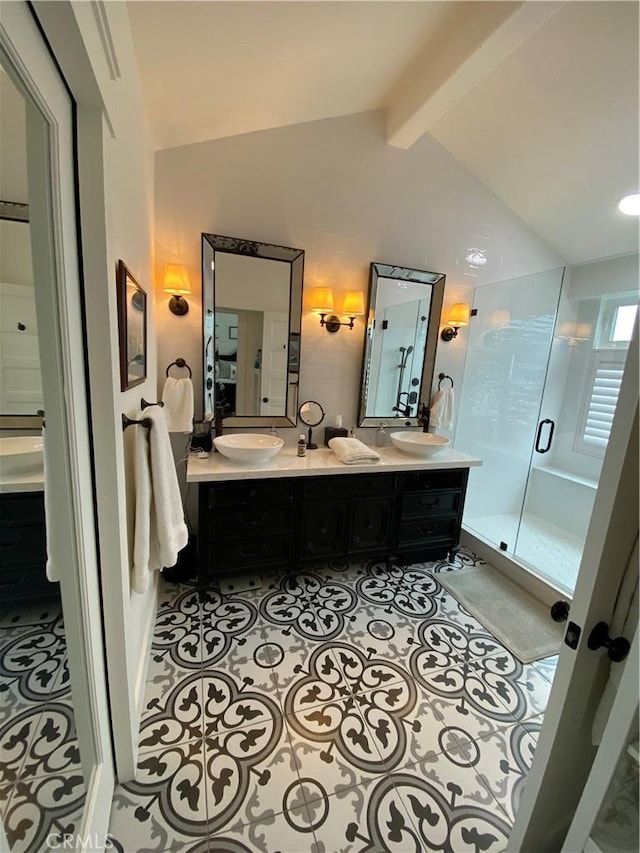 bathroom featuring a sink, lofted ceiling with beams, a shower stall, tile patterned flooring, and double vanity