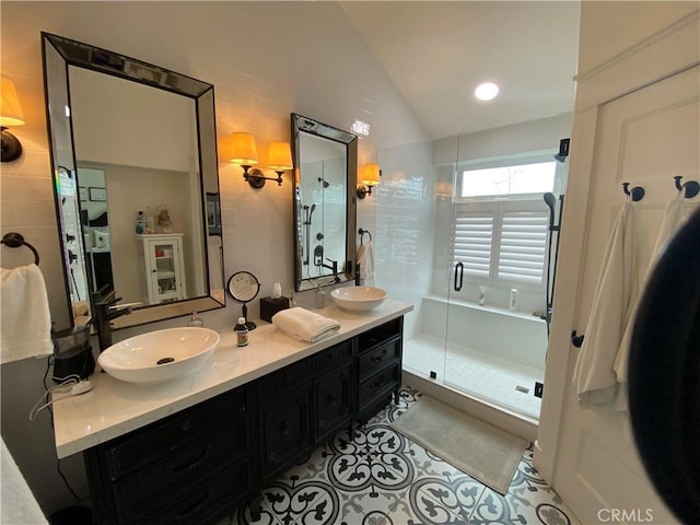 bathroom featuring a sink, lofted ceiling, a shower stall, and tile patterned floors