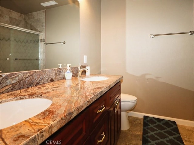 full bath with baseboards, toilet, double vanity, a stall shower, and a sink