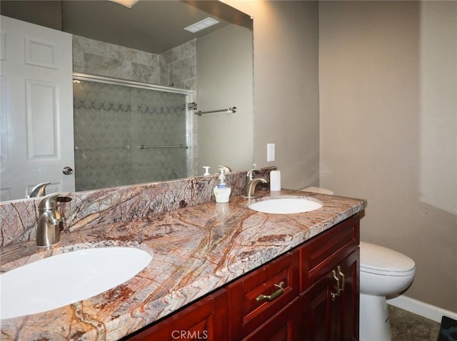 bathroom with double vanity, toilet, a stall shower, and a sink