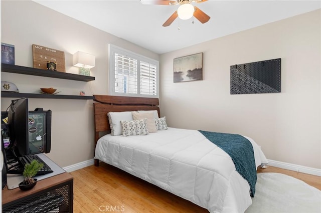 bedroom featuring light wood-style floors, baseboards, and a ceiling fan